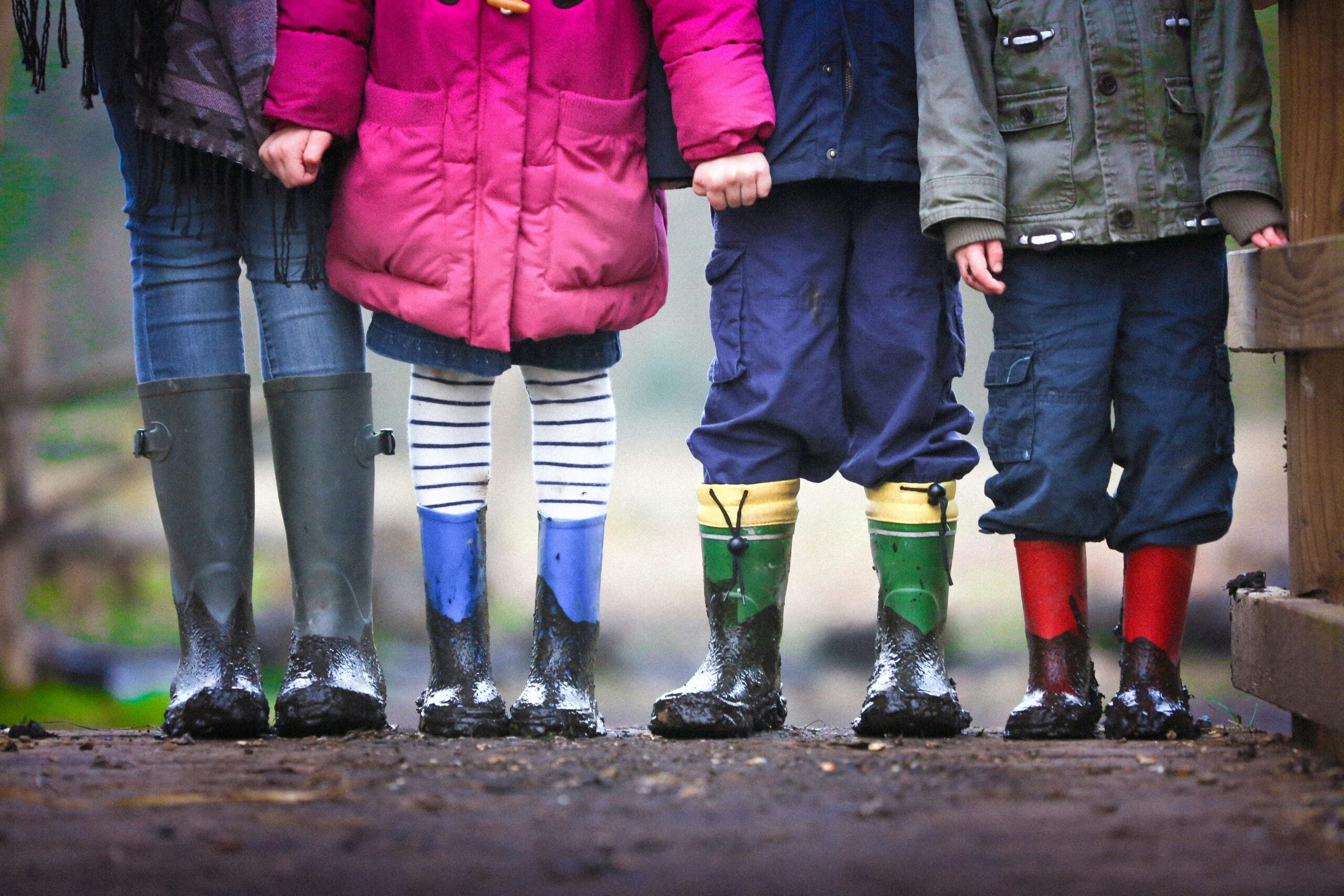 Vier Kinder spielen draußen auf einem sonnigen Spielplatz – Symbol für Kinderabsicherung, Vorsorge und eine sichere Zukunft.